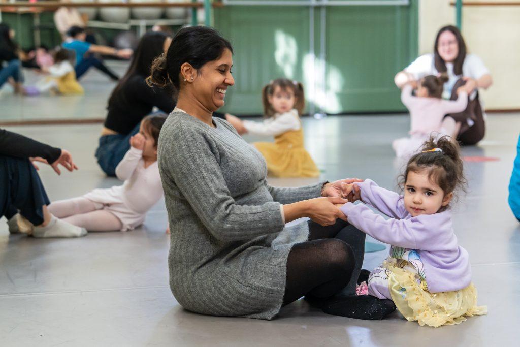Mother and daughter participating in toddler ballet class together
