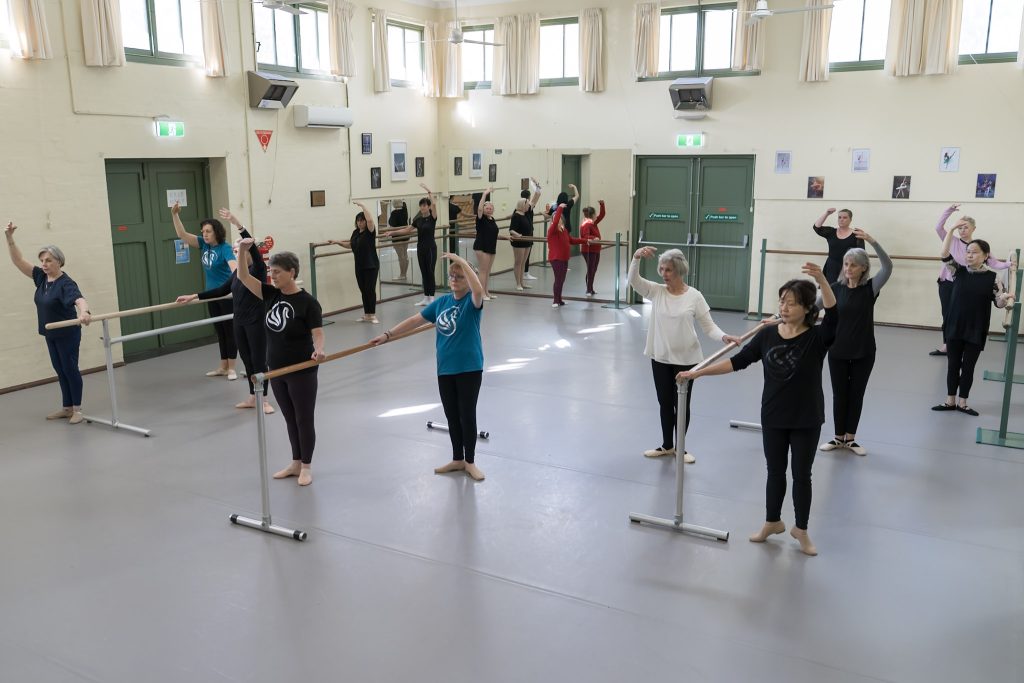 Older ballet class aged 55+ dancing at the barre. Silver Swans